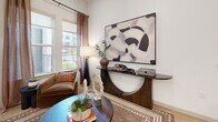 This well-appointed single-floor residence in Plano, Texas offers a thoughtfully designed layout encompassing two bedrooms, two bathrooms, a dedicated office, and four closets. The open-concept kitchen is a standout feature, showcasing two-tone cabinetry with dark lower and light upper cabinets, a white quartz waterfall island, subway tile backsplash, stainless steel appliances, and warm wood-tone flooring that flows throughout the main living areas. The adjacent dining area provides an intimate setting, while the living room exudes a calm, sophisticated ambiance. The primary bedroom features large windows with outdoor views and ample natural light, complemented by well-organized walk-in closets with multi-tier shelving and hanging systems. The second bedroom also enjoys generous natural light and outdoor views. The office benefits from soaring ceilings, a ceiling fan, and a bright window — a versatile space suitable for work or fitness. Both bathrooms are finished with large-format tile, dark vanity cabinetry, white quartz countertops, and modern matte black fixtures. The full bath includes a tub-shower combination with floor-to-ceiling tile surround. Throughout, the home maintains a clean, modern aesthetic with neutral tones and quality finishes.