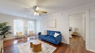 This well-appointed one-bedroom, one-bathroom residence in Austin, TX offers a thoughtfully organized layout across a single floor. The open living and dining area serves as the heart of the home, featuring rich hardwood flooring, crown molding, and a ceiling fan that add a classic, polished character. Large windows flood the space with natural light, while terracotta tile flooring in the sitting nook near the entryway provides a warm, inviting contrast to the wood floors throughout the rest of the unit.

The galley-style kitchen is efficiently designed with dark cabinetry lining both sides, white countertops, a double sink, and white appliances including a range and refrigerator, maximizing functionality in a compact footprint. A dedicated dining area features chair-rail wainscoting, adding a refined architectural detail.

The bedroom is a comfortable retreat highlighted by crown molding, a ceiling fan, hardwood floors, and large windows dressed with sheer curtains that allow ample natural light. Two closets provide generous storage throughout the unit.

The bathroom includes a full tub-shower combination with white subway tile surround. Two dedicated closets offer practical storage solutions, completing this efficient and well-designed Austin residence.