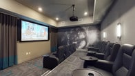 This purpose-built screening room delivers an immersive cinematic experience within a single-level layout. The room is anchored by a large projection screen mounted at the front wall, paired with a ceiling-mounted projector that ensures a sharp, high-quality picture. Rows of plush, reclining black leather-style chairs are arranged in a tiered, stadium-seating configuration, providing unobstructed sightlines from every seat. Each chair is accompanied by a personal side table equipped with cup holders, adding a convenient, theater-inspired touch. The back wall serves as a dramatic focal point, featuring a bold large-scale mural depicting a classic film reel amid atmospheric smoke, reinforcing the cinematic theme throughout. Recessed ceiling lighting provides subtle ambient illumination, while wall sconces offer additional accent lighting without disrupting the viewing experience. The flooring is finished in a patterned carpet that complements the overall design aesthetic. Neutral-toned walls with teal accents and curtained side panels contribute to the room's polished, professional atmosphere, making it a well-appointed space for private screenings and entertainment gatherings.