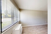 Located at 1333 West Grand River Avenue in Howell, Michigan, this two-bedroom, one-bathroom unit offers a well-organized single-floor layout designed for comfortable everyday living. The living room greets you with light wood-style laminate flooring, neutral walls, and a large window fitted with horizontal blinds that invite natural light and offer views of the surrounding neighborhood. A wall-mounted HVAC unit provides climate control with ease. The galley-style kitchen is a functional highlight, featuring gray shaker cabinets, granite-look countertops, a stainless-steel sink, and white appliances including a refrigerator and range — all set on matching wood-style flooring. The primary bedroom is a comfortable retreat, offering angled ceilings, generous window coverage with blinds, and hardwood-style flooring. The second bedroom is finished with warm, neutral carpet and a window that lets in natural light, along with a double-door closet providing ample storage. The full bathroom includes a tub/shower combination with grab bars, a single-sink vanity, and wood-style flooring, maintaining the clean, cohesive aesthetic found throughout. Neutral tones and consistent finishes give the entire space a fresh, move-in-ready feel.
