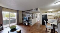 This well-appointed 2-bedroom, 1-bathroom residence in Colorado Springs, Colorado, offers a functional and stylish single-floor layout. The combined living and dining area serves as the heart of the home, showcasing warm wood-style flooring that flows throughout the main living spaces. A striking reclaimed wood accent wall in the living room creates a bold focal point, complementing the neutral tones of the surrounding walls. A sliding glass door opens to a private balcony, allowing natural light to fill the space and providing outdoor views. The kitchen features white cabinetry, black appliances including a full-size refrigerator and electric range, and connects seamlessly to a dedicated dining area. The full bathroom is finished with a white vanity, built-in storage, and modern light fixtures. Both bedrooms are carpeted and equipped with ceiling fans for year-round comfort. The primary bedroom offers a generous footprint with a closet, natural window light, and ample room for furnishings. The second bedroom is comparably sized and well-lit. A textured ceiling is consistent throughout the home, adding a classic finish. The overall layout is efficient and cohesive, making practical use of every area within this Colorado Springs residence.