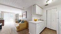 Located at 500 Main St in East Haven, Connecticut, this single-floor residence offers a practical and well-organized layout across two bedrooms, one bathroom, a living room, and a dedicated laundry area. The living room provides a comfortable, open feel with neutral-toned walls, plush carpeting, and a seamless connection to the kitchen, which features white cabinetry and appliances. The spacious primary bedroom is generously sized, offering room to move freely, and includes carpeted flooring, a window that invites natural light, and a wall-mounted air conditioning unit for year-round comfort. A sliding glass door in the bedroom area opens to an exterior view, adding brightness and a sense of openness. The second bedroom shares the same clean, neutral aesthetic. The full bathroom is bright and well-appointed, featuring a tub-shower combination with crisp white tile and wood-look flooring. White cabinetry with a utility sink anchors the kitchen area, with an adjacent closet and access to the carpeted laundry room, providing added convenience. Throughout the residence, a consistent palette of warm neutrals and white trim creates a cohesive, move-in-ready atmosphere suited for comfortable everyday living.