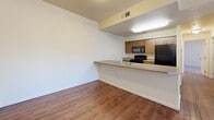 Located at 4980 Copper Springs View in Colorado Springs, Colorado, this single-floor, 2-bedroom, 2-bathroom unit offers a practical and well-organized layout. The open-concept kitchen and living area serves as the heart of the unit, featuring wood-tone cabinetry, a peninsula countertop with a double stainless steel sink, and black appliances including a refrigerator, range, and built-in microwave. Hardwood-style flooring runs through the kitchen and living areas, providing a clean, cohesive look.

Both bedrooms are carpeted and equipped with ceiling fans and vertical blinds over windows that bring in natural light. The primary bedroom is a comfortable size and includes access to a balcony with an outdoor view, adding a desirable extension of the living space. A dedicated closet provides additional storage.

The two bathrooms are functionally designed, each featuring a tub-shower combination with white tile surround and built-in shelving. One bathroom includes a wood-tone vanity with a countertop basin and hardwood-style flooring. Neutral wall tones throughout the unit contribute to a bright, consistent ambiance well-suited for everyday living.
