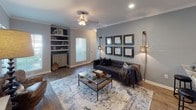 This single-floor residence offers a thoughtfully designed layout with a cohesive cool-gray color palette that flows throughout the space. The living room serves as the heart of the home, featuring wood-look flooring, crown molding, recessed lighting, and a striking built-in shelving unit with a contrasting dark accent alcove. A large area rug and gallery wall arrangement lend the room a polished, curated feel.

The kitchen is outfitted with white cabinetry, granite-style countertops, a classic subway tile backsplash, and stainless steel appliances including a refrigerator, range, and microwave. Double doors open to a convenient laundry area, adding practical functionality.

The primary bedroom is generously sized with plush carpeting, a ceiling fan, and a private en-suite bathroom accessed through a connected doorway. The en-suite features wood-look flooring, white cabinetry with dark countertops, and a shower-tub combination. The second bedroom also features carpeted flooring, a ceiling fan, and a bold dark accent wall, with its own nearby full bathroom that mirrors the clean, functional design of the primary bath. Each room is well-proportioned, offering comfortable living across the entire floor plan.