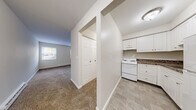 Located at 480 Main St in West Haven, Connecticut, this efficiently designed single-floor unit offers a thoughtful layout that maximizes comfort and functionality. The combined living and dining area is bright and welcoming, featuring wall-to-wall carpeting, neutral-toned walls, and multiple windows that allow natural light to fill the space. A baseboard heating unit and wall-mounted AC unit ensure year-round comfort, while the windows offer pleasant views of the surrounding neighborhood.

The kitchen is compact yet well-equipped, showcasing white cabinetry with brushed nickel hardware, rich dark marble-style countertops, tile flooring, and a white electric range with overhead ventilation — a clean and practical space for everyday cooking.

The bathroom is finished in a crisp, all-white palette with classic square tile surrounding a full soaking tub and shower combination, complemented by tile flooring for a clean, timeless look.

Throughout the unit, four closets provide generous storage solutions, helping to keep the space organized and clutter-free. A hallway connects the various areas of the unit seamlessly. The overall ambiance is clean, neutral, and move-in ready, making it a practical and comfortable home in West Haven.