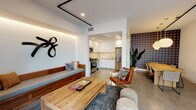 Located in the heart of West Los Angeles at 11311 La Grange, this single-floor unit showcases a thoughtfully designed open-concept layout that seamlessly integrates the living, dining, and kitchen areas into one cohesive space. The interior is finished with polished concrete floors throughout, lending a modern, industrial character that ties the entire space together.

The kitchen is outfitted with sleek, flat-front white cabinetry that extends to the ceiling, light quartz countertops, a subtle mosaic tile backsplash, and a full suite of stainless steel appliances including a gas range, over-range microwave, dishwasher, and a large French door refrigerator. A single-basin sink with a gold-tone faucet adds a refined touch.

The living area is warm and inviting, featuring built-in LED cove lighting that casts a soft ambient glow, an industrial-style black track rail system on the ceiling, and a custom wood bench seat. A bold sculptural wall accent adds artistic character, while an adjacent accent wall with a graphic circular pattern brings visual depth to the dining area.

The entry foyer is clean and minimal, featuring a stainless steel elevator door alongside a standard unit entry door, highlighting the building's modern infrastructure. Recessed lighting throughout ensures the space is well-illuminated, contributing to its bright and contemporary ambiance.