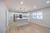 Located at 4386 Jackson St in Punta Gorda, FL, this single-floor home has been thoughtfully updated with modern finishes throughout. Light-toned luxury vinyl plank flooring runs continuously across the living areas and bedrooms, creating a bright, cohesive aesthetic that complements the neutral gray walls and crisp white trim.

The kitchen is a standout feature, outfitted with white shaker-style cabinetry accented by gold hardware, a subway tile backsplash, quartz countertops, and a full suite of stainless steel appliances including a refrigerator, electric range, and over-the-range microwave. A kitchen island with pendant lighting adds both function and style, while multiple windows invite natural light and outdoor views.

The bedrooms are generously proportioned, each equipped with ceiling fans featuring gold-toned fixtures and recessed lighting. At least one bedroom includes a built-in closet with sliding doors, offering practical storage. The living and entry areas are open and airy, with natural light filtering through large windows.

The bathroom showcases a walk-in glass shower with large-format stone-look tile on the walls and a mosaic tile floor, complemented by a built-in bench — a clean and refined finish. Throughout the home, recessed lighting, fresh paint, and consistent flooring tie together a move-in ready interior designed for comfortable Florida living.