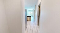 Located at 11025 26 Avenue Northwest in Edmonton, Alberta, this well-appointed one-bedroom, one-bathroom unit offers a thoughtfully designed single-floor layout with a clean, contemporary aesthetic throughout. Light wood-look flooring flows seamlessly across all rooms, creating a cohesive and airy feel.

The kitchen is efficiently designed in an L-shaped configuration, featuring crisp white cabinetry with ample storage, white quartz countertops, a stainless steel sink, and a full suite of stainless steel appliances including a refrigerator, electric range, over-the-range microwave, and dishwasher. A white subway tile backsplash adds a polished finish. The kitchen opens directly into the living area, which benefits from large windows that bring in generous natural light and offer views of the surrounding neighbourhood.

The bedroom is a comfortable size, highlighted by a bright window and baseboard heating, providing a quiet and functional retreat. A connecting hallway leads conveniently to the full bathroom, which features marble-look tile surround on the tub/shower combo, a white vanity with integrated countertop, and matching light flooring. An adjacent open shelving closet area provides practical built-in storage.

The overall design is modern and neutral, making the space versatile and move-in ready.