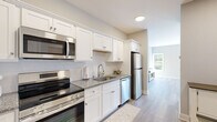 Located at 67-71 Minerva Street in Derby, CT, this thoughtfully designed one-bedroom, one-bathroom unit offers a clean, modern aesthetic across a single floor. Light gray walls and durable hardwood-style flooring flow consistently throughout, creating a cohesive and bright interior.

The galley-style kitchen is a standout feature, showcasing white shaker cabinetry, granite countertops, a white subway tile backsplash, and a full suite of stainless steel appliances including a refrigerator, range, built-in microwave, and dishwasher. A deep undermount sink with a modern faucet completes the well-equipped space.

The generously sized bedroom serves as a comfortable retreat, featuring multiple windows that invite abundant natural light, including a bay-style window arrangement that adds architectural charm. Two closet doors offer ample storage within the room.

The bathroom is finished with the same neutral palette and hardwood-style flooring, featuring a granite-topped vanity with shaker-style cabinetry and a full glass-enclosed shower, providing a clean and functional design.

Throughout the unit, white trim, recessed lighting, and flush-mount fixtures contribute to a polished, move-in-ready feel. The overall ambiance is calm and contemporary, making efficient use of every square foot.