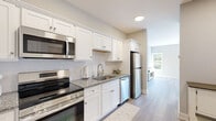 Located at 67-71 Minerva Street in Derby, CT, this thoughtfully designed one-bedroom, one-bathroom unit offers a clean, modern aesthetic across a single floor. Light gray walls and durable hardwood-style flooring flow consistently throughout, creating a cohesive and bright interior.

The galley-style kitchen is a standout feature, showcasing white shaker cabinetry, granite countertops, a white subway tile backsplash, and a full suite of stainless steel appliances including a refrigerator, range, built-in microwave, and dishwasher. A deep undermount sink with a modern faucet completes the well-equipped space.

The generously sized bedroom serves as a comfortable retreat, featuring multiple windows that invite abundant natural light, including a bay-style window arrangement that adds architectural charm. Two closet doors offer ample storage within the room.

The bathroom is finished with the same neutral palette and hardwood-style flooring, featuring a granite-topped vanity with shaker-style cabinetry and a full glass-enclosed shower, providing a clean and functional design.

Throughout the unit, white trim, recessed lighting, and flush-mount fixtures contribute to a polished, move-in-ready feel. The overall ambiance is calm and contemporary, making efficient use of every square foot.