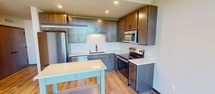 This compact yet well-designed 490 square foot apartment in Madison, WI, offers a harmonious blend of functionality and style. The space comprises one bedroom, one bathroom, a kitchen, and a hallway, all thoughtfully arranged on a single floor. The primary bedroom, measuring 110 square feet, features a modern ceiling fan and neutral-toned walls, creating a serene atmosphere.

The kitchen is a highlight, boasting an open-concept design with sleek wooden cabinetry, stainless steel appliances, and a stylish white tile backsplash. The L-shaped layout maximizes efficiency, while recessed lighting and under-cabinet illumination enhance the bright, contemporary feel. A small island provides additional counter space and casual seating.

The bathroom continues the modern aesthetic with a white bathtub-shower combination, a simple vanity, and wood-look flooring that matches the rest of the apartment. Throughout the space, warm wood-toned flooring adds a touch of warmth and continuity.

Despite its modest size, the apartment feels spacious thanks to its thoughtful layout and neutral color palette. The hallway connects the rooms seamlessly, contributing to the overall flow of the space. Located at 531 W Washington Ave, this apartment offers urban living in a well-appointed, efficient package.