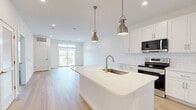 Located at 2220 North Susquehanna Trail in York, PA, this thoughtfully designed one-bedroom, one-bathroom unit offers a clean, modern aesthetic throughout its single-floor layout. Light-toned hardwood flooring flows seamlessly through the open-concept living, dining, and kitchen areas, creating a bright and cohesive feel enhanced by recessed lighting and crisp white walls.

The kitchen is a standout feature, outfitted with white shaker-style cabinetry, white quartz countertops, a classic subway tile backsplash, stainless steel appliances, and a central island with pendant lighting — ideal for both cooking and casual dining. The living area benefits from generous natural light pouring in through large windows and sliding glass doors that open to an outdoor area, giving the space an airy, open ambiance.

The spacious primary bedroom is finished with plush carpeting, a ceiling fan, a dedicated closet, and a window overlooking the outdoors. The full bathroom is well-appointed with white cabinetry, a quartz vanity, a framed walk-in shower with sliding glass doors, and matching hardwood-style flooring that maintains the home's clean design language throughout.