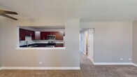 Located at 19 Briar St in Glen Ellyn, IL, this single-floor unit offers a well-organized layout with a cohesive neutral palette throughout. The living area is generously sized, featuring plush carpeting, a ceiling fan, and a large window that allows natural light to fill the space. A wall-mounted air conditioning unit provides supplemental climate control, complementing the baseboard heating found throughout the unit.

The kitchen is a standout feature, designed with rich cherry wood cabinetry, sleek bar-pull hardware, and deep granite countertops. Stainless steel appliances—including a range, microwave, and dishwasher—add a modern touch, while a pass-through opening connects the kitchen to the living area, promoting an open, communicative flow.

The bedrooms are carpeted and finished in warm neutral tones. One bedroom includes a walk-in closet alongside a standard closet, as well as a window with natural views and a wall-mounted air conditioning unit. Additional bedrooms are well-proportioned with ample wall space and baseboard heating.

The bathroom features wood-look tile flooring, a tub-shower combination with white tile surround, brushed nickel accessories, and a vanity with storage. The overall ambiance of the space is clean, functional, and move-in ready.
