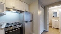 Located at 69 Edbert St in Chicopee, MA, this single-floor unit offers a practical and well-organized layout designed for comfortable everyday living. The open-concept living area is finished with durable wood-style vinyl flooring in a neutral gray tone, lending a clean and modern aesthetic throughout. Neutral-toned walls complement the flooring, creating a bright, cohesive atmosphere. A window along the living area wall allows natural light to filter in, while a wall-mounted air conditioning unit and baseboard heating ensure year-round climate control.

The kitchen is efficiently designed and positioned adjacent to the living space, separated by a peninsula counter with a stone-look laminate surface—ideal for casual dining or food preparation. White shaker-style cabinetry with ample upper and lower storage lines the kitchen walls, complemented by stainless steel appliances, including a Whirlpool refrigerator, an electric coil range with oven, and an under-cabinet range hood. A sink with surrounding counter space adds further functionality.

A full bathroom features a clean, white tub and shower combo with chrome fixtures. Additional storage is available through a large closet near the entry. The unit's straightforward, single-level design prioritizes practicality and ease of use.
