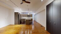 Located in Philadelphia's storied Old City neighborhood, this two-floor space artfully combines historic character with contemporary updates. The main level features gleaming, original hardwood floors that run throughout an open living and kitchen area, bathed in light from recessed fixtures, track lighting, and a ceiling fan overhead. The fully equipped kitchen is a standout, showcasing wood-grain cabinetry, white quartz countertops, a classic subway tile backsplash, stainless steel appliances, and a central island with pendant lighting — offering both functionality and style. The open layout of the main floor creates a generous sense of flow between the living and kitchen spaces. A clean, tiled bathroom with bright white walls completes the upper level. The lower floor presents a striking contrast: expansive, open rooms with concrete flooring, exposed wooden ceiling beams, raw brick walls, and track lighting, lending the space an industrial, loft-like quality ideal for a variety of uses. Together, the two floors offer a compelling blend of refined modern living and raw architectural character, making this a distinctive and versatile property in the heart of Philadelphia.