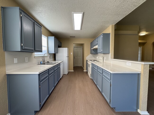 Freshly painted shaker cabinets, extended counter space, and a deep sink make meal prep a pleasure. - 2806 Maria Dr