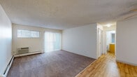 Located in Lakewood, Colorado, this 2-bedroom, 2-bathroom unit offers a practical and comfortable single-floor layout designed for everyday living. The open living room is a welcoming space featuring plush wall-to-wall carpeting, light wood flooring at the entryway, a textured ceiling, and sliding glass doors dressed with vertical blinds that invite natural light. A wall-mounted air conditioning unit and baseboard heating provide year-round climate control.

The kitchen is efficiently laid out with warm wood cabinetry, light laminate countertops, a stainless steel sink, and white appliances including an electric range and dishwasher. It connects seamlessly to the living area, creating an open, functional flow.

Both bedrooms are carpeted and offer a calm, neutral palette with textured ceilings and windows with vertical blinds. Each room includes closet access for ample storage. A hallway connects the bedrooms to the two bathrooms, each featuring wood-toned vanity cabinetry, light countertops, and large mirrors. One bathroom includes a full tub-shower combination. Wood-style flooring carries through the bathroom and kitchen areas, tying the space together with a consistent, clean aesthetic throughout.