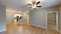 Located in Mandeville, Louisiana, this well-appointed single-story, 3-bedroom, 2-bathroom home offers a thoughtfully designed layout with consistent modern finishes throughout. Light wood-style flooring runs continuously across all living areas, complemented by neutral gray and taupe wall tones that create a clean, cohesive aesthetic.

The open-concept living and dining area features a ceiling fan with light fixture and flows seamlessly into the kitchen, which is equipped with white shaker-style cabinetry, granite countertops, a full suite of stainless steel appliances including a gas range, microwave, refrigerator, and dishwasher, as well as a double sink and open shelving.

A well-lit hallway connects the bedrooms and bathrooms, with a stylish chandelier accenting the transition space. Both bathrooms feature white vanity cabinetry, granite countertops, framed mirrors, and wood-look flooring. The bedrooms are generously sized, with ceiling fans and walk-in closet access visible in at least one room.

A dedicated laundry room houses a full-size washer and dryer alongside upper white cabinetry for additional storage. The home's single-floor plan ensures easy navigation, and the consistent use of quality materials throughout gives the space a polished, move-in-ready feel.