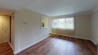 Located at 2211 Valleywood Dr SE in Grand Rapids, Michigan, this single-floor unit offers a well-organized layout with a cohesive design throughout. The living area is finished with rich hardwood flooring and features crown molding along the ceiling, adding a classic architectural detail. A large window with vertical blinds allows natural light to fill the space while offering views of the surrounding greenery. A pass-through opening connects the living area to the kitchen, enhancing the sense of openness between the two spaces.

The kitchen is outfitted with dark, raised-panel cabinetry that provides ample storage, complemented by granite countertops that extend across an L-shaped configuration. A stainless steel sink is centrally positioned, and the space includes a range and additional appliances. Hardwood flooring continues into the kitchen, maintaining visual consistency with the main living area.

The bedroom is carpeted for comfort and receives natural light through a generously sized window fitted with vertical blinds. The full bathroom features a granite-topped vanity with an undermount sink, a large mirror, and a white tub and shower surround with built-in shelving. Neutral wall tones are used consistently throughout, contributing to a calm and cohesive overall ambiance.