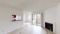Located at 1320 S Victoria Ave in Oxnard, CA, this single-story, one-bedroom, one-bathroom unit offers a well-organized layout across a comfortable footprint. Light wood-style flooring runs throughout, complementing crisp white walls and textured ceilings to create a clean, bright aesthetic.

The open living and dining area serves as the heart of the unit, anchored by a fireplace and a ceiling fan overhead. A pass-through window connects this space to the galley-style kitchen, which features warm wood cabinetry lining both walls, a stainless steel sink, electric range, and ample counter space. Natural light filters in through vertical blinds, and sliding glass doors lead directly to a private patio.

The bedroom is generously proportioned, offering a natural light-filled window with vertical blinds and two closets — one a standard closet and the other a mirrored sliding-door closet — providing excellent storage. The full bathroom is neatly appointed with a combined tub and shower, a vanity with a white countertop, and matching light wood-style flooring. Additional conveniences include a dedicated laundry area and a hallway connecting all rooms efficiently. The entry area provides a welcoming transition into the unit with a wall-mounted heater and flush ceiling light.