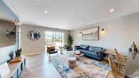 Located at 440 Green Bay Rd in Highwood, Illinois, this thoughtfully designed single-floor entertainment and lounge space offers a dynamic blend of comfort, style, and recreation. Light hardwood flooring flows throughout, tying together distinct zones that each serve a unique social purpose.

Upon entry, a bold blue accent wall with a large wall-mounted mirror and a sleek console table set a modern, welcoming tone. Warm wall sconces and recessed lighting provide layered illumination throughout. The lounge area features a blue leather sofa, leather accent chairs, a marble coffee table, and a colorful area rug, all arranged around a large flat-screen TV — perfect for relaxed gatherings.

A dedicated game area accommodates a full-size pool table beneath a striking slatted pendant light, with vibrant artwork adorning the surrounding walls. Adjacent to this is a well-appointed bar area with counter seating, pendant lighting, and bold, colorful artwork that energizes the space.

Natural light pours in through large windows and a sliding glass door that opens to an outdoor terrace, extending the entertaining footprint beyond the interior. The overall ambiance is modern and inviting, with cohesive design elements — from the carefully chosen décor to the thoughtful layout — making this a versatile space well-suited for both lively events and casual lounging.