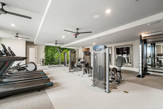 Gimnasio con pared de vegetación, equipo de entrenamiento cardiovascular y de fuerza - Hawthorne at Friendly