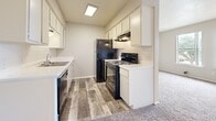 Located at 4500 Campus Dr in Fort Worth, TX, this one-bedroom, one-bathroom unit offers a practical and efficiently arranged floor plan across a single level. The kitchen is a standout feature, outfitted with white cabinetry, white countertops, a tile backsplash, and black appliances including a refrigerator, electric range, and dishwasher. Wood-look flooring runs throughout the kitchen, providing a clean and durable surface that transitions into the carpeted living areas. The bedroom is a comfortably sized retreat, featuring plush wall-to-wall carpet, neutral gray walls, and a textured ceiling. It includes direct access to a dedicated closet as well as the full bathroom, adding convenience to the layout. The bathroom is clean and straightforward, featuring a full tub-shower combo with white tile surround and standard fixtures. Neutral tones are carried throughout the unit, creating a cohesive and understated aesthetic. The overall layout is compact yet functional, making efficient use of the available space. This unit is well-suited for individuals or couples seeking a manageable, low-maintenance living space in Fort Worth, Texas.