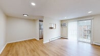 Located at 46 Camp St in Middletown, CT, this one-bedroom, one-bathroom unit offers a well-organized layout across a single floor. Light-toned hardwood flooring runs consistently throughout the space, contributing to a clean, cohesive aesthetic.

The combined kitchen and living area forms the heart of the unit. The kitchen is equipped with stainless steel appliances, including a refrigerator and range, complemented by white cabinetry, granite-style countertops, and a window that brings in natural light. A pass-through opening connects the kitchen to the living area, enhancing the open feel. The living room features recessed lighting, a wall-mounted air conditioning unit, baseboard heating, and a sliding glass door dressed with vertical blinds, providing outdoor access and additional natural light.

The bedroom is a generously sized private retreat with recessed lighting, a window with blinds, and baseboard heating. The bathroom is finished in white tile, featuring a tub-shower combination with a window above, a white vanity, and a mirror.

A hallway connects the main living areas, completing the efficient and functional floor plan.