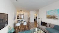 This single-floor residence at 270 Waverly Avenue in Mamaroneck, New York, presents a thoughtfully designed open-concept layout with a clean, contemporary aesthetic. The living and dining areas flow seamlessly together, anchored by warm hardwood-style flooring and crisp white walls that create a bright, airy atmosphere. Recessed lighting throughout the main living space is complemented by natural light filtering in through roller shade-equipped windows.

The kitchen is a standout feature, offering white cabinetry, a light-toned countertop peninsula with bar seating, a tile backsplash, and a full suite of stainless steel appliances including a French door refrigerator, microwave, and range. A sleek linear pendant light above the peninsula adds a modern, refined touch.

The bedroom is generously proportioned, offering two sets of double closets for ample storage, large windows with roller shades, and hardwood-style flooring that continues from the main living area, maintaining a cohesive design throughout.

The full bathroom features large-format tile flooring, a dark-cabinetry vanity with a white sink, a mirrored medicine cabinet with integrated lighting, and a shower-tub combination. The overall design of this residence reflects a modern sensibility with functional, well-appointed spaces suited for contemporary living.