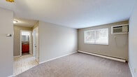 Located at 680 Smith Ct in Rocky River, OH, this one-bedroom, one-bathroom unit offers a practical and well-organized single-floor layout. The living room is a comfortable, open space finished with neutral-toned carpet and warm beige walls, bathed in natural light from a large window with views of surrounding greenery. A baseboard heating system runs along the exterior wall, and a wall-mounted air conditioning unit ensures year-round climate control. The layout flows from the living area into the bedroom, which also features soft carpeting, a window with outdoor views, and its own baseboard heating. Two closets provide ample storage throughout the unit. The kitchen is equipped with warm wood-toned cabinetry, a freestanding electric range, and durable tile flooring, offering an efficient and functional cooking space. The bathroom features a full tub-and-shower combination with classic white tiling accented by a bold black tile border, adding a clean, timeless aesthetic. Textured ceilings are present throughout the unit, contributing to the overall character of the space. The floorplan model reveals a compact yet thoughtfully arranged layout, making efficient use of every area. This unit is a straightforward, move-in-ready space in a well-established Rocky River location.