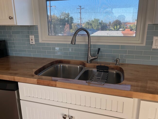 Beautifully sealed butcher block counter tops and 2-tub kitchen sink with disposal. North facing window. - 4470 Swift Ave