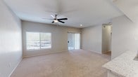 Located at 17374 N 89th Ave in Peoria, Arizona, this single-story home offers a well-designed, functional layout. The spacious living area is finished with plush carpeting, neutral-toned walls, and a ceiling fan with light fixture. Large windows and a sliding glass door with vertical blinds allow abundant natural light and provide access to the outdoors. The galley-style kitchen is thoughtfully appointed with white shaker cabinetry, granite-look countertops, a subway tile backsplash, stainless steel appliances including a range, microwave, and dishwasher, and wood-look vinyl flooring. The bedrooms are carpeted and each features a ceiling fan and window with blinds, creating comfortable, well-lit retreats. The bathrooms are clean and functional — one includes a combined tub and shower, while the other features a walk-in shower stall, both with granite-topped white vanities and wood-look flooring. The consistent use of neutral finishes throughout the home creates a cohesive and move-in ready aesthetic well-suited to the sunny Peoria, AZ climate.