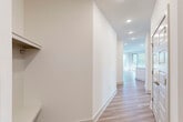 This single-story home in Mount Holly, NC offers a thoughtfully designed layout across three bedrooms and two bathrooms. The open-concept kitchen and living area serves as the heart of the home, featuring light hardwood-style flooring, recessed lighting, and a large central island with a white quartz countertop and undermount sink. The kitchen is outfitted with gray shaker-style cabinetry, a white subway tile backsplash, stainless steel appliances, and a window overlooking greenery outside.

The living area is bright and airy, with multiple windows and a sliding glass door that floods the space with natural light, complemented by a ceiling fan overhead. A light-filled hallway connects the main living areas to the bedrooms, with built-in shelving adding practical storage.

The primary bedroom is generously proportioned and includes a walk-in closet fitted with wire shelving. Secondary bedrooms feature neutral carpet flooring and windows that invite natural light. The bathrooms are finished with gray vanity cabinetry, wood-look tile flooring, and a tiled tub-shower surround. Clean white walls and consistent finishes throughout give the home a cohesive, modern aesthetic.