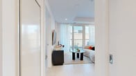 Located at 70 Nicholas St in the heart of Ottawa, this thoughtfully designed one-bedroom, one-bathroom unit offers a sleek, modern aesthetic with an efficient and well-appointed layout. Light hardwood flooring and crisp white walls run throughout, creating a bright and cohesive atmosphere.

The open-concept kitchen and living area forms the heart of the unit. The kitchen features floor-to-ceiling cabinetry in a soft wood-tone finish, a white quartz countertop, stainless steel appliances including a built-in oven and microwave, and a central island with bar seating — ideal for casual dining. A large window floods the space with natural light and offers city views.

The living room is anchored by large floor-to-ceiling windows and a glass door leading to a private balcony, where urban Ottawa views can be enjoyed. The space is well-proportioned and inviting, with sheer curtains softening the natural light.

The bedroom is a calm and restful retreat, featuring a sliding closet door, access to the balcony, and generous windows with sheer drapery. The bathroom is finished with large-format stone-look tile, a soaker tub, and clean, minimalist fixtures.

This unit combines contemporary urban design with functional living, making it an excellent choice in one of Ottawa's vibrant downtown neighbourhoods.
