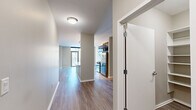 Located in Chicago's Fulton River District, this well-appointed one-bedroom, one-bathroom residence offers a thoughtfully designed floor plan across a single level. Hardwood-style flooring flows through the main living areas, lending a clean, contemporary aesthetic throughout.

The open-concept kitchen, dining, and living area serves as the heart of the home. The kitchen is equipped with stainless steel appliances — including a gas range, microwave, and refrigerator — complemented by rich dark cabinetry, a light glass tile backsplash, and sleek marble-look quartz countertops. Pendant lighting above the countertop adds a polished finishing touch. A pantry provides additional storage convenience.

The living and dining area extends toward floor-to-ceiling windows and a glass door leading to a private balcony, filling the space with natural light and offering views of the surrounding Chicago skyline.

The bedroom features plush carpet flooring, generous wall space, and a large sliding glass door that opens to a secondary outdoor area with city views. Two well-organized closets with built-in shelving systems offer ample storage.

The bathroom is finished with large-format tile flooring, a dark-cabinetry vanity with marble-look countertop, and a soaking tub with full gray tile surround. The overall design balances modern finishes with functional, comfortable living.
