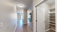 Located in Chicago's Fulton River District, this well-appointed one-bedroom, one-bathroom residence offers a thoughtfully designed floor plan across a single level. Hardwood-style flooring flows through the main living areas, lending a clean, contemporary aesthetic throughout.

The open-concept kitchen, dining, and living area serves as the heart of the home. The kitchen is equipped with stainless steel appliances — including a gas range, microwave, and refrigerator — complemented by rich dark cabinetry, a light glass tile backsplash, and sleek marble-look quartz countertops. Pendant lighting above the countertop adds a polished finishing touch. A pantry provides additional storage convenience.

The living and dining area extends toward floor-to-ceiling windows and a glass door leading to a private balcony, filling the space with natural light and offering views of the surrounding Chicago skyline.

The bedroom features plush carpet flooring, generous wall space, and a large sliding glass door that opens to a secondary outdoor area with city views. Two well-organized closets with built-in shelving systems offer ample storage.

The bathroom is finished with large-format tile flooring, a dark-cabinetry vanity with marble-look countertop, and a soaking tub with full gray tile surround. The overall design balances modern finishes with functional, comfortable living.