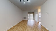 Located at 90 Bristol Station in Carteret, New Jersey, this single-floor unit offers a clean, modern aesthetic with thoughtfully designed living spaces. The open living area is anchored by warm-toned hardwood-style flooring and crisp white walls, creating a bright and airy atmosphere. Track lighting overhead adds a contemporary touch, while a sliding glass door with vertical blinds opens to an outdoor area, allowing natural light to flow freely into the space. An additional windowed area nearby further enhances the sense of openness.

The galley-style kitchen is outfitted with white shaker cabinetry, light countertops, and stainless steel appliances including a gas range, microwave, and refrigerator. A notable feature is the in-unit laundry room, accessible directly from the kitchen, providing added convenience. A double-door closet in the main living area offers generous storage alongside a front entryway door.

The bedroom is carpeted for comfort and features a large window dressed with blinds, filling the room with soft natural light. The bathroom is well-appointed with large-format tile flooring, a floating white vanity with ample cabinet storage, a wide mirror with overhead lighting, and a tub-shower combination accented by wood-look tile surrounds. This unit combines functional design with modern finishes for comfortable everyday living.