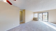 This single-floor residence at 3882 Northumberland Terr in Fremont, CA offers a practical and well-organized layout. The spacious living room is finished with neutral-toned carpet and warm beige walls beneath a textured ceiling, creating a calm, understated ambiance. A sliding glass door leads to a private balcony, allowing natural light to fill the room, while a wall-mounted A/C unit ensures year-round comfort. A dedicated hallway connects the living area to the rest of the unit, providing a clear and functional flow throughout the space.

The kitchen features a pass-through counter that opens toward the living area, promoting an open feel. White cabinetry and a full-size refrigerator contribute to a clean, efficient workspace. A ceiling fan with a light fixture overhead adds both ventilation and practicality.

The bedrooms are carpeted and bathed in natural light through large windows with blinds that frame views of the surrounding neighborhood. Baseboard heating in one bedroom adds an additional layer of comfort. The bathroom is clean and straightforward, equipped with a full soaking tub and shower combination with chrome fixtures and a white surround, complemented by neutral walls and tile flooring.