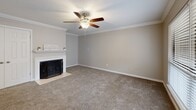 This well-appointed 2-bedroom, 2-bathroom single-story home in Memphis, Tennessee offers a thoughtfully designed layout with a comfortable, functional flow throughout. The living room serves as the heart of the home, featuring a classic wood-burning fireplace with a white mantle, crown molding, a textured ceiling, and a ceiling fan — all set over plush carpeting that extends through the main living areas. A large front-facing window fills the entry area with natural light. The kitchen is a standout, outfitted with white shaker cabinets, granite countertops, stainless steel appliances, and a raised breakfast bar that opens to the dining area. Hardwood-style flooring runs through the kitchen and dining spaces. Both bedrooms are generously sized, each with ceiling fans and carpeted floors. The primary bedroom includes a walk-in closet with built-in shelving. The bathrooms are clean and functional — one features a granite-topped vanity with white cabinetry, while the other includes a tub-shower combination with tile surround. Additional highlights include five closets, a dedicated pantry, in-unit laundry, and a private patio. The home is situated in the 38119 zip code of Memphis, TN.