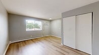 Located in Norwood, OH, this efficient one-bedroom, one-bathroom unit offers a practical and well-designed single-floor layout. Throughout the space, light-toned hardwood flooring and soft gray-neutral walls create a clean, cohesive aesthetic that feels open and easy to personalize.

The living area provides a comfortable, open feel with a closet for added storage, seamlessly connecting to the kitchen. The kitchen is equipped with white cabinetry, a countertop with a sink, a refrigerator, and a stovetop range, offering all essential cooking amenities in a compact, functional arrangement. Natural light enters through windows with blinds, lending the kitchen a bright, airy character.

The bedroom is a well-proportioned private retreat featuring a large window overlooking greenery, a baseboard heating unit, and a spacious sliding-door closet. The natural light and outdoor views contribute to a calm and comfortable atmosphere.

The bathroom is finished with classic white mosaic tile flooring and white walls, housing a full bathtub with a showerhead, a toilet, and a vanity. A window with blinds allows for natural ventilation and light.

Overall, this unit presents a clean, minimalist design with practical finishes, making it a straightforward and functional living space in the Norwood area.