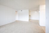 Located at 17101 Springdale Street in Huntington Beach, California, this one-bedroom, two-bathroom residence offers a well-organized, single-floor layout with a bright and neutral aesthetic throughout. The open-concept living, dining, and kitchen area forms the heart of the home, with plush carpeting in the living and dining spaces flowing naturally toward a sliding glass door that opens onto a private balcony with pleasant neighborhood views and natural greenery. The galley-style kitchen is efficiently designed, featuring white cabinetry, granite-style laminate countertops, a deep white sink, tile flooring, and a paneled ceiling light fixture that provides ample illumination. A pantry adds convenient additional storage. The bedroom is a comfortable, carpeted retreat with its own sliding glass door to the balcony, vertical blinds for light control, and access to two generous closets, including a walk-in style space with a hanging rod and shelving. The two bathrooms include a full bath with a soaking tub and shower combination finished in clean white surround, and a second bath featuring a wide vanity with a granite-style countertop, an undermount sink, and a large mirror with overhead lighting. Utility rooms provide practical storage, completing this functional and well-appointed Huntington Beach residence.