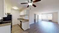 Located at 8561 De Soto Ave in the Canoga Park neighborhood of Los Angeles, this single-floor unit offers a clean, modern interior designed for comfortable everyday living. The open-concept layout connects the kitchen and living area seamlessly, creating a bright and airy atmosphere enhanced by a large window that allows ample natural light to fill the space.

The kitchen is well-appointed with white cabinetry, granite-style countertops, a stainless steel double-basin sink, a dishwasher, and a full-size refrigerator. A ceiling fan with an integrated light fixture is centrally positioned overhead, providing both ventilation and ambient lighting across the kitchen and adjoining living area.

Wood-style laminate flooring runs consistently throughout the main living spaces and bedroom areas, contributing to a cohesive and contemporary aesthetic. The bedroom offers a spacious, neutral environment with clean white walls, generous floor space, and a closet. The bathroom is fitted with a full soaking tub and shower combination, chrome fixtures, and matching wood-style flooring, maintaining the unit's consistent design language.

Overall, the space presents a bright, well-maintained interior with a practical single-floor layout, modern finishes, and a neutral color palette that provides a versatile foundation for a variety of living arrangements.