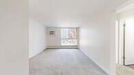 Located at 2000 S University Blvd in Denver, CO, this 2-bedroom, 2-bathroom residence offers a practical and comfortable single-floor layout. The living room features neutral carpet flooring, clean white walls, and a large window with vertical blinds that invites natural light and outdoor views of surrounding trees. A wall-mounted HVAC unit and baseboard heating are present throughout, ensuring year-round comfort. The layout connects the living area to a designated dining room and a functional kitchen equipped with standard appliances and wood-look flooring. Both bedrooms are carpeted and feature ceiling fans with integrated lighting. The primary bedroom includes a closet with bifold doors, while additional closets throughout the unit provide generous storage. A hallway connects the bedrooms to two full bathrooms. One bathroom features a tub/shower combination with built-in shelving, a white vanity with ample counter space, a mirrored medicine cabinet, and wood-look tile flooring. The second bathroom offers a similarly clean, bright design with a wide vanity countertop and mirror. With four closets total and a straightforward floor plan, this residence delivers efficient use of space in a convenient Denver location.