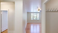 Located at 1330 Boren Ave in Seattle, WA, this two-bedroom, one-bathroom residence offers a thoughtfully organized single-floor layout. Warm hardwood flooring runs throughout the main living areas and both bedrooms, lending a cohesive and inviting feel to the entire space. The generously sized primary bedroom features a ceiling fan with light fixture, multiple windows that invite natural light, and a closet for ample storage. The second bedroom also benefits from a window with outdoor views of surrounding greenery. The kitchen is well-equipped with rich, dark wood cabinetry, granite-style countertops, a stainless steel sink, a dishwasher, and a range, all complemented by a window that brightens the workspace. The full bathroom includes a combined tub and shower with white tile surround and wood-look flooring. A dedicated laundry area houses a stacked washer and dryer unit, adding everyday convenience. The hallway connects the rooms efficiently, with clean white walls and trim maintained throughout. Ceiling fans in multiple rooms enhance comfort and airflow. This residence provides a practical and comfortable living environment in a central Seattle location.