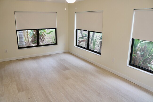 Amplia sala de estar con mucha luz natural y persianas opacas. - 33 63rd St