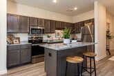 Located at 2401 Sunrise Ridge Way in Knoxville, Tennessee, this single-story residence offers a thoughtfully designed layout with modern finishes throughout. The welcoming entryway sets an inviting tone, featuring light wood-style flooring, crisp white walls, and tasteful décor that carries through the entire home.

The kitchen is a standout feature, outfitted with rich dark cabinetry, granite countertops, a central island, and a full suite of stainless steel appliances including a range, microwave, dishwasher, and refrigerator — providing both style and functionality for everyday cooking.

The living area is bright and comfortable, bathed in natural light through large windows with views of the surrounding landscape. A ceiling fan adds to the airy feel, while the open flow connects seamlessly to a dining nook — ideal for entertaining or relaxed daily living.

The bedrooms are generously sized and serene, each with wood-style flooring, ample natural light, and ceiling fans. The bathrooms are clean and well-appointed, featuring granite vanities, wood cabinetry, and a shower-tub combination.

A dedicated laundry room with full-size washer and dryer adds everyday convenience. The home's neutral palette, consistent flooring, and cohesive design create a warm, livable ambiance throughout.