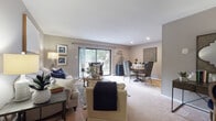 This single-floor residence offers a thoughtfully arranged layout that balances comfort and functionality. The open-concept living and dining area serves as the heart of the home, featuring soft neutral-toned walls, plush wall-to-wall carpeting, and recessed lighting. Large sliding glass doors flood the space with natural light and provide direct access to an outdoor balcony, framing pleasant views of surrounding greenery. The living area is generously proportioned, offering ample room for relaxed seating arrangements, while the adjacent dining space provides a seamless flow for everyday living and entertaining.

The kitchen is outfitted with warm oak cabinetry, dark countertops, a full suite of white appliances including a refrigerator, range, and dishwasher, and easy-to-maintain tile flooring. It is compact yet efficient, with plentiful cabinet storage reaching to the ceiling.

The bedroom is a calm retreat with neutral carpeting and soft, muted wall tones. A set of double bi-fold closet doors reveals generous built-in storage with hanging rods. The bathroom features a clean, fully tiled tub-shower combination with crisp white finishes, contributing to the overall fresh and well-maintained character of the home.