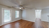Located at 500 Kraft Dr in Clarksville, TN, this single-floor, 2-bedroom, 2-bathroom home offers a practical and comfortable layout. The open living room flows into the kitchen area, both finished with warm hardwood-style flooring. The living room features a ceiling fan, a glass-paned exterior door, and a window that brings in natural light. The kitchen is equipped with light wood cabinetry, a sink, ample counter space, and includes appliances such as a refrigerator and dishwasher, with easy access to the rest of the unit. Both bedrooms are carpeted and include ceiling fans; the primary bedroom offers a generous footprint with access to a closet, while the second bedroom features a window for natural light. Each bathroom is finished with hardwood-style flooring, a wood-toned vanity with sink, and a toilet. One bathroom includes a full tub/shower combo. The dedicated laundry room features wire shelving and washer/dryer connections, adding everyday convenience. A textured ceiling is present throughout much of the home. The overall aesthetic is neutral and functional, providing a clean canvas throughout.