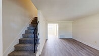 Located at 736 West Kingsway in Middle River, Maryland, this two-story, three-bedroom, one-bathroom home offers a clean and functional layout across two well-proportioned floors. The main level welcomes you with a bright, open living room featuring durable luxury vinyl plank flooring and neutral cream-toned walls, creating a fresh and inviting atmosphere. Natural light flows in through large windows, and a carpeted staircase with a sleek black metal railing leads to the upper level. The kitchen is well-equipped with light wood cabinetry, gray countertops, white appliances including a gas range, microwave, and dishwasher, and a large window that brings in ample natural light. A pantry provides additional storage convenience. Upstairs, three bedrooms each feature the same consistent LVP flooring and neutral walls, with windows offering views of the surrounding neighborhood. The primary bedroom provides a comfortable and functional retreat. A shared full bathroom, hallways, a utility room, and a closet round out the home's practical layout. Throughout both floors, the consistent use of light flooring and bright, neutral finishes gives the home a clean, move-in-ready feel.