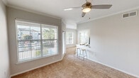 Located in Houston, TX, this single-floor residence offers three bedrooms, three bathrooms, and a well-planned layout designed for comfortable everyday living. The kitchen is a functional highlight, featuring white shaker cabinetry, marble-style countertops, stainless steel appliances including a refrigerator, microwave, and electric range, and a peninsula with bar seating that opens to the living area. The living space is bright and welcoming, with large windows that bring in natural light, crown molding accents, a ceiling fan, and a breakfast bar that connects to the kitchen. Each bedroom is finished with plush carpeting, ceiling fans, and ample natural light; bedrooms include access to closets, one of which features a walk-in with built-in shelving. The bathrooms are clean and straightforward, with white tile tub-and-shower combinations, wood-look flooring, and vanity storage. A dedicated laundry room houses a full-size washer and dryer with overhead shelving for added storage. The unit also includes a private balcony overlooking the surrounding community, offering an outdoor retreat. Two closets and two hallways contribute to the overall storage and circulation throughout the home.